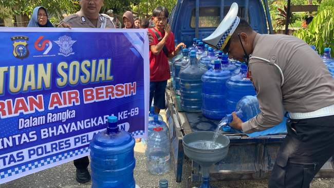Satlantas Polres Pelalawan Bagikan Air Bersih Kepada Masyarakat Desa Makmur